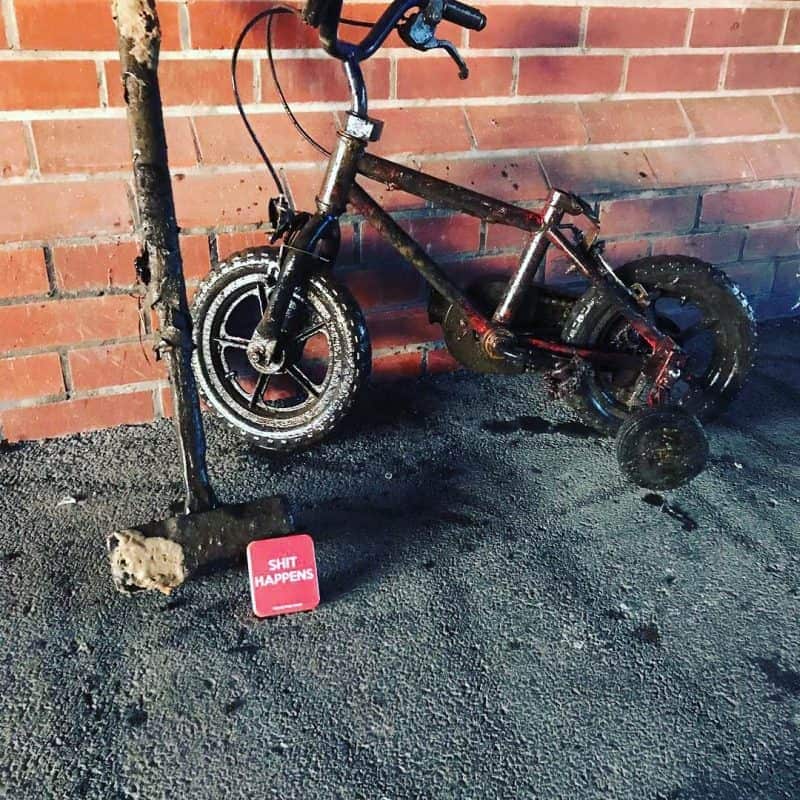 ciocan și bicicletă de copii sprijinită de un zid