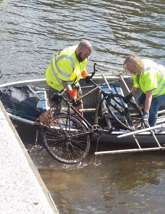 Pescarii încarcă bicicleta pe barcă