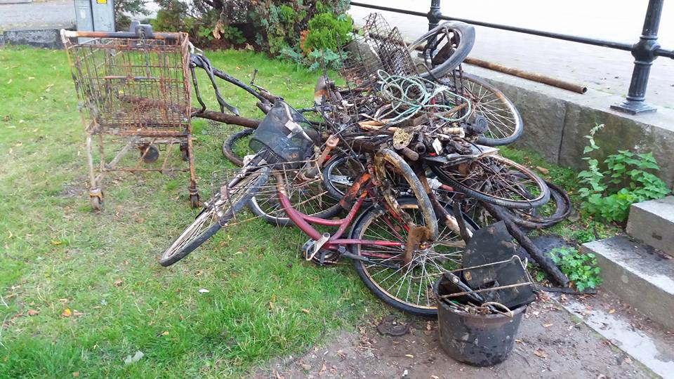 Grămadă de biciclete și un cărucior de cumpărături