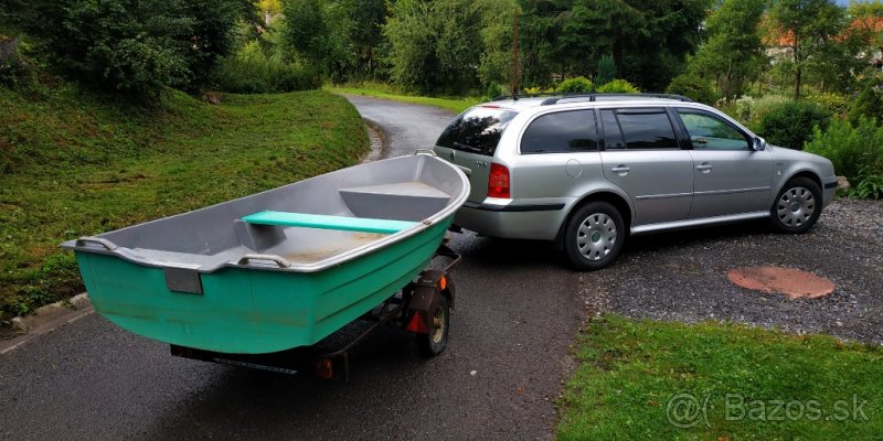 Barcă din fibră de sticlă pe o remorcă, trasă de un Octavia