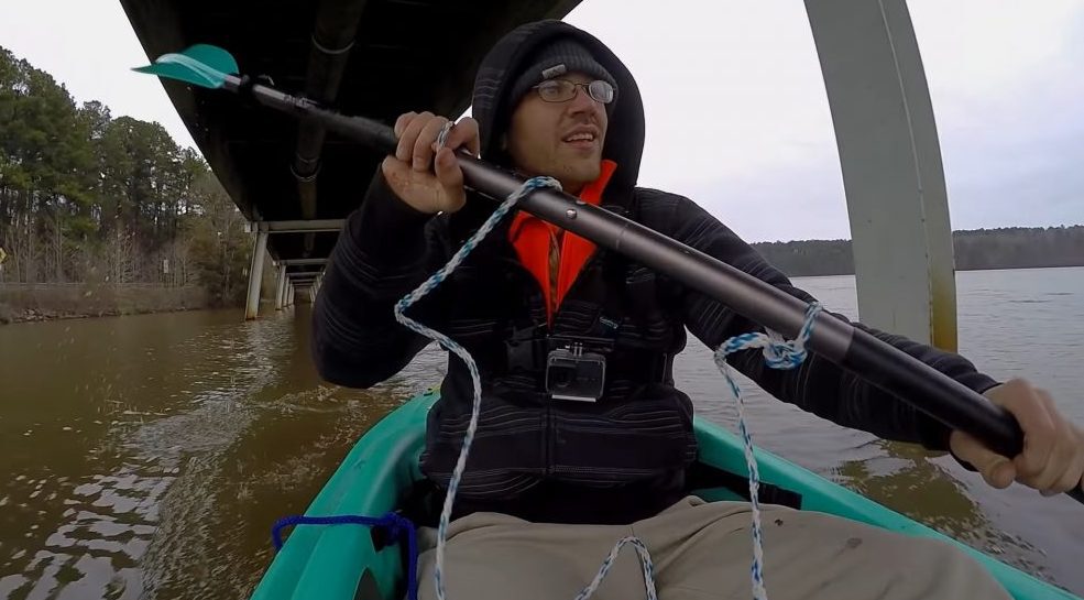 Magnet fisher coboară pe râu într-o barcă cu pagaie dublă