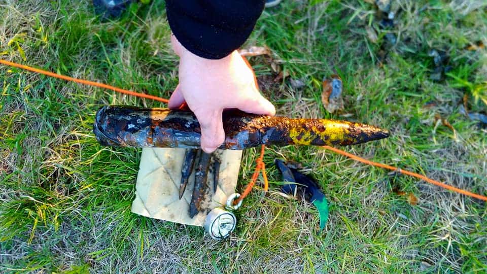 Un magnet fisher ține în mână un cartuș de mitralieră